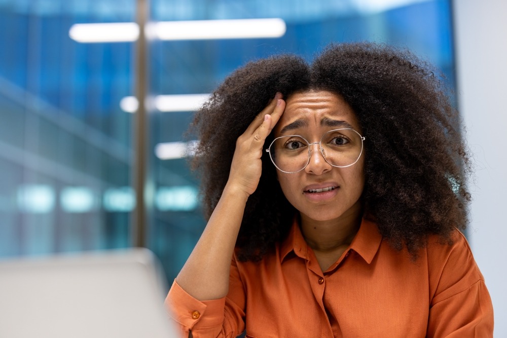 A,Concerned,Young,Woman,,Wearing,Glasses,And,An,Orange,Shirt,
